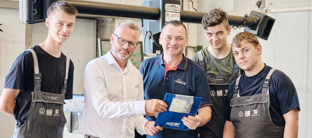 Vier Mitarbeiter und Geschäftsführer in der Werkstatt